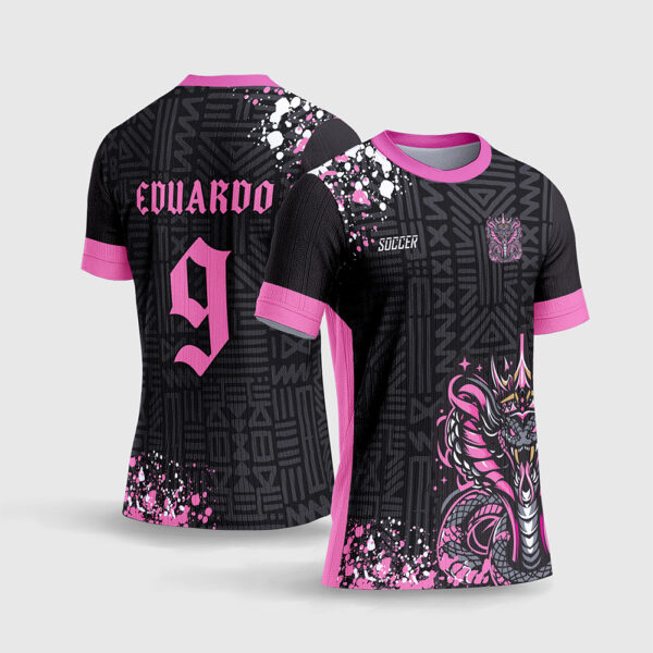 Arte Vetor Camisa InterClasse Cobra Rei Rosa.jpg apresenta o mockup de um fardamento escolar preto e rosa choque com ilustração de cobra naja coroada, fundo coberto por texturas de grafismos tribais em marca d'água, detalhes de respingos de tinta nos ombros e numeração com fonte gótica em sublimação total CorelDRAW.