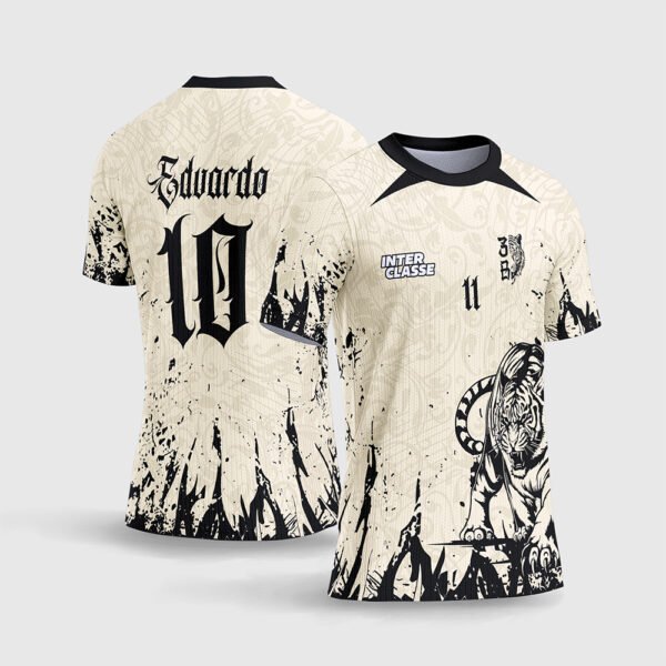 Arte Vetor Camisa Interclasse Tigre Bege.jpg apresenta o mockup de um fardamento esportivo de interclasse na cor bege cream off-white com textura de arabescos, estampa frontal de um tigre preto em posição de caça com respingos grunge, e layout traseiro com o número 10 e nome Eduardo em fonte gótica para sublimação total CorelDRAW.