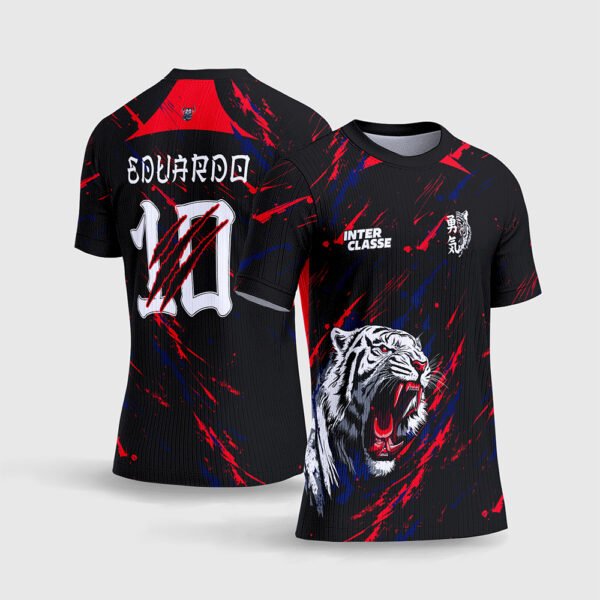 Arte Vetor Camisa Interclasse Tigre Feroz.jpg apresenta o mockup de um fardamento esportivo de interclasse na cor preta com respingos em vermelho e azul royal, estampa frontal de um tigre branco rugindo com bocat amarela/vermelha, e layout traseiro com o número 10 rasgado por garras e nome Eduardo em sublimação total CorelDRAW.